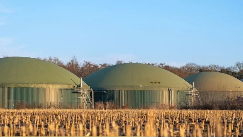Biomethane digesters at agricultural biogas plant set beside farmland