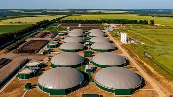 Aerial view of biogas plant with green dome digesters and farmland