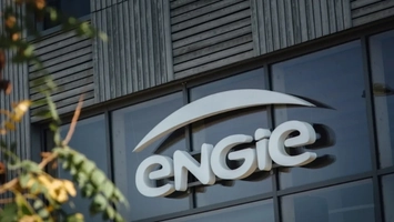 Engie corporate logo on a glass-fronted building facade with foliage in the foreground
