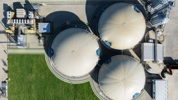 Aerial view of three large biogas digester tanks with dome covers