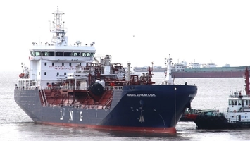 Avenir Advantage LNG tanker on a waterway, tugboat alongside, ship in the background