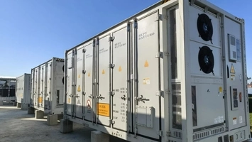 Battery energy storage containers branded REPT Battero lined up at an outdoor facility under a clear blue sky