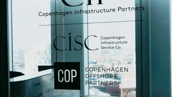 Glass door printed with the logos of CIP, CiSC, and Copenhagen Offshore Partners against a blurred skyline